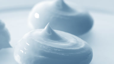 Macro crane turntable shot of three blue cosmetic cream drops