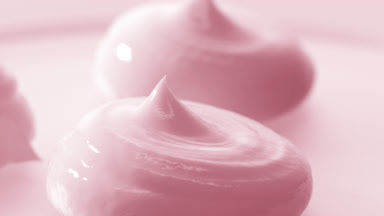 Macro crane turntable shot of three pink cosmetic cream drops