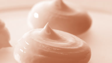 Macro crane turntable shot of three beige cosmetic cream drops