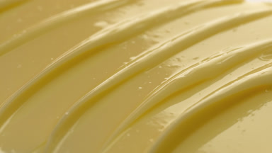 Macro shot of yellow skincare cream with moving light source