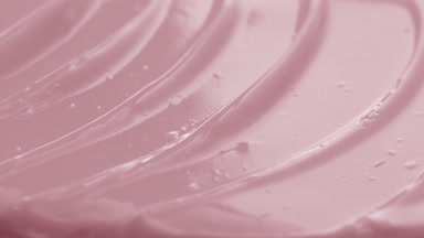 Macro shot of pink rosehip night cream with moving light source