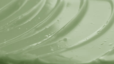 Macro shot of green retinol night cream with moving light source