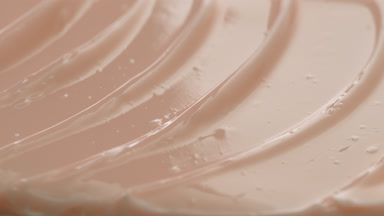 Macro shot of beige collagen night cream with moving light source