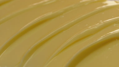 Macro of yellow vitamin C night cream with moving light source