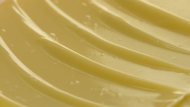 Macro shot of yellow nourishing cream with moving light source
