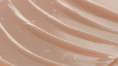 Macro shot of beige nourishing cream with moving light source
