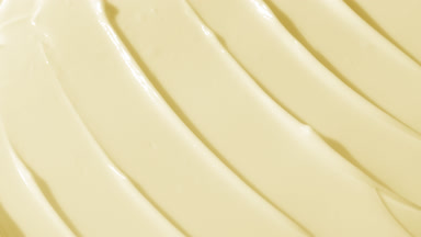 Side view macro shot of yellow face care cream with carrot oil
