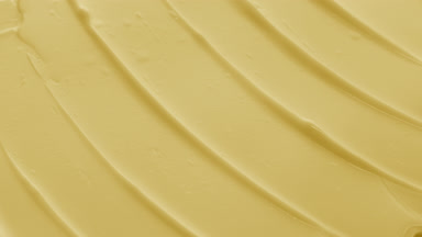 Macro of yellow face care cream with carrot oil in the shadow