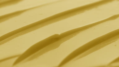 Macro crane shot of yellow night cream texture in the shadow