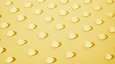 Crane shot of moving transparent drops on yellow background