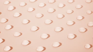 Macro crane shot of moving transparent drops on beige background
