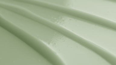Macro shot of green cream texture with reflection of light on it