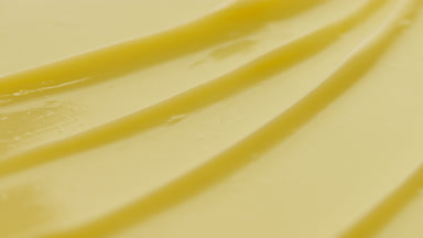 Yellow nourishing cream furrow texture with reflection of light