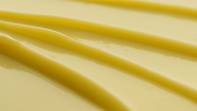 Yellow eye care cream furrow texture with a reflection of light
