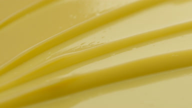 Yellow face care cream furrow texture with a reflection of light
