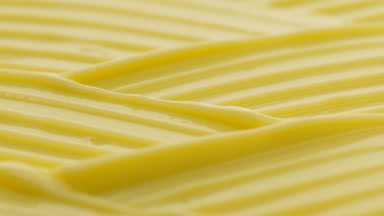 Macro crane shot of yellow day cream wave texture
