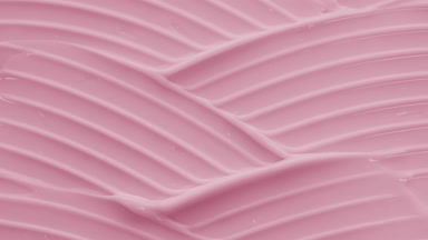Macro crane shot of pink day cream with rose oil wave texture