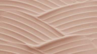 Macro crane shot of beige day cream with almond oil wave texture