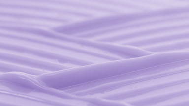 Macro crane shot of violet moisturizing cream wave texture