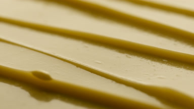 Macro turntable shot of yellow anti-aging cream furrow texture