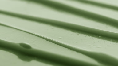 Macro turntable shot of green anti-aging cream furrow texture