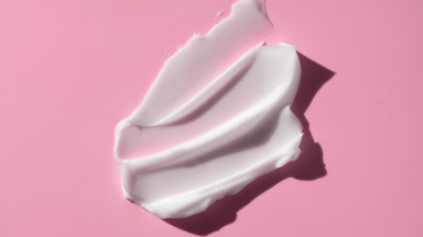 Crane shot of whitening cream smears on pale blue background
