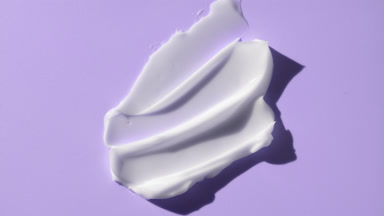 Crane shot of whitening cream smears on violet background