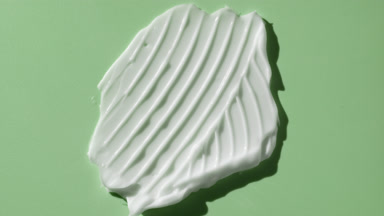 Macro of white cream smear furrow texture on green background