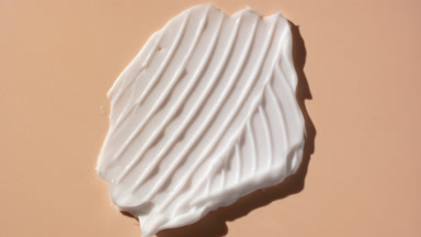 Macro of white cream smear furrow texture on beige background