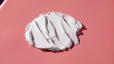 Turntable shot of white day cream smears on pink background