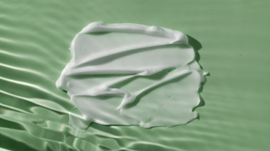 White body cream smears on green background under rippling water