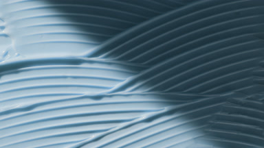 Macro of blue lifting cream wave texture appears from the shadow