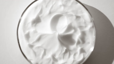 White cream with hyaluronic acid on watch glass round is turning