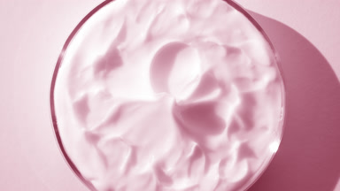 Pink cream with rose oil on watch glass round is turning