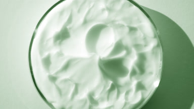Green cream with green tea extract on watch glass round is turning