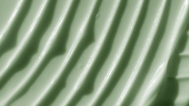 Macro of green retinol lifting cream with moving light source