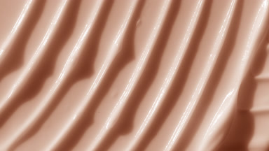 Macro shot of beige lifting cream with moving light source