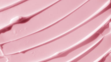 Top view macro shot of pink body care cream with rose oil