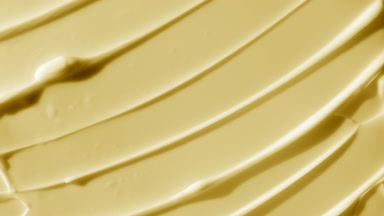 Top view macro shot of yellow body care cream with cocoa butter