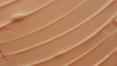 Macro of beige moisturizing cream with peach extract in shadow