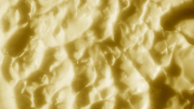 Top view macro shot of yellow banana nutrition cream surface