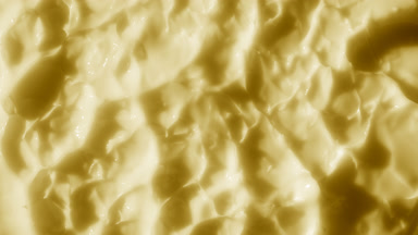 Top view macro of yellow nourishing cream with lanolin surface