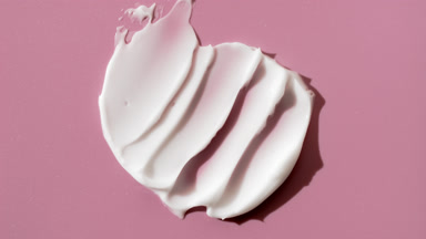 Whitening cream smears on pink background with changing lighting