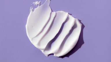 White cream smears on purple background with changing lighting