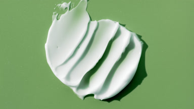 White cream smears on green background with changing lighting
