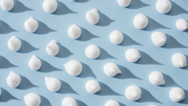 Whitening cream drops on blue background with moving lighting