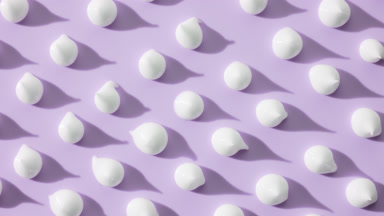 Whitening cream drops on violet background with moving lighting