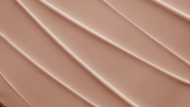 Top view macro shot of beige hydrating cream furrow texture