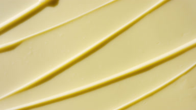 Top view macro turntable shot of yellow day cream wave texture