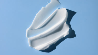 Lightening cream smears on blue background with moving lighting